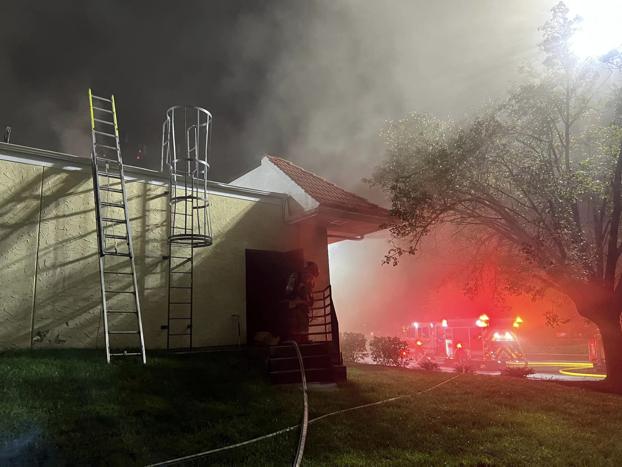 Ladders thrown against a building on fire. 